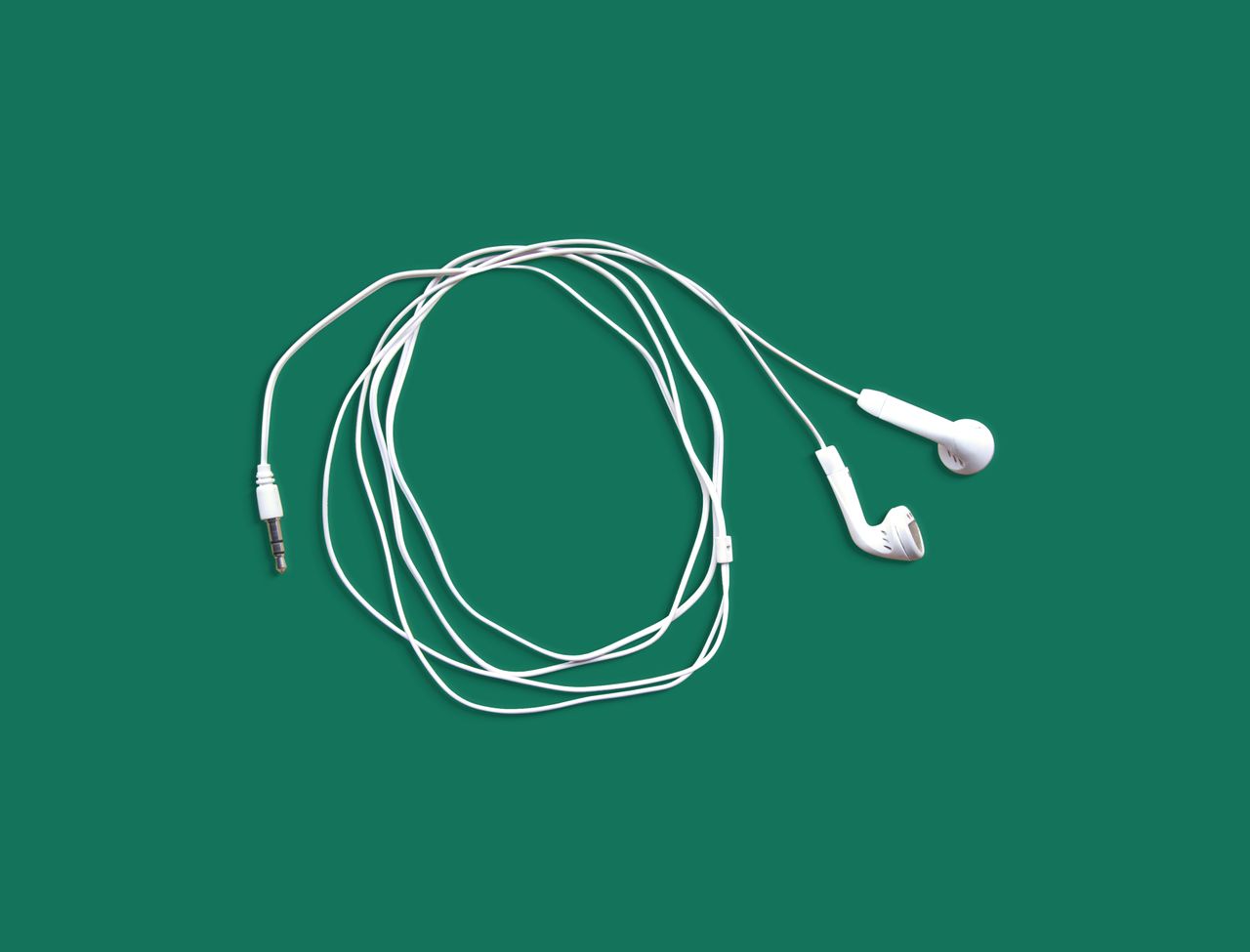 White earphones neatly displayed on a solid green background in a flat lay style.